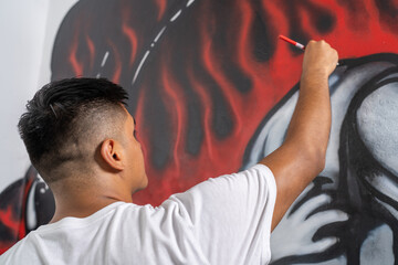 Muralist touches up details of a mural with a brush