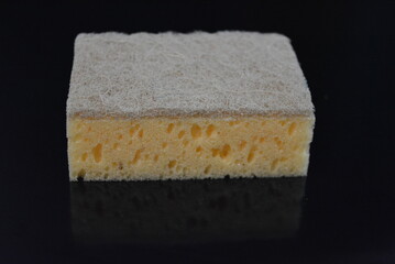 Things that are often used in the household. Colored washcloths for washing dishes are arranged on a glossy black background.