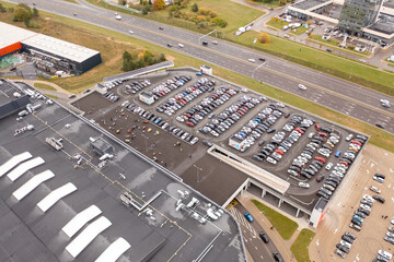 Drone photography of almost full parking place near a shopping mall during autumn cloudy day