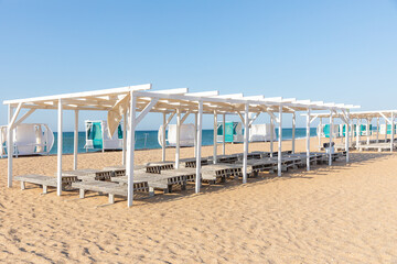 Vacation holidays background wallpaper - beach long chairs under tent on beach.