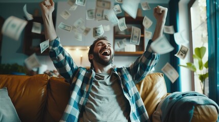 Joyful man sitting on a couch with fists raised in excitement as money cascades around him, symbolizing financial success or a lottery win.