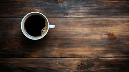 Rustic Charm: Top View of a Dark Coffee Cup Resting on a Weathered Wooden Table