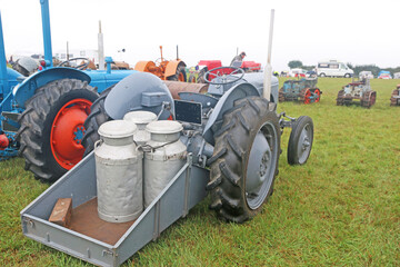 Vintage tractor towing milk churns