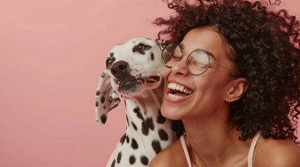A joyful woman in sunglasses receives a loving lick on the face from a playful Dalmatian against a radiant red background, showcasing their affectionate bond. - obrazy, fototapety, plakaty