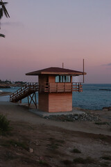 Wooden lifeguard safety tower station along the boardwalk beach of Paphos, Cyprus during sunset