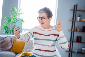 Photo of positive friendly lady wear striped pullover spectacles waving hi video call modern device...