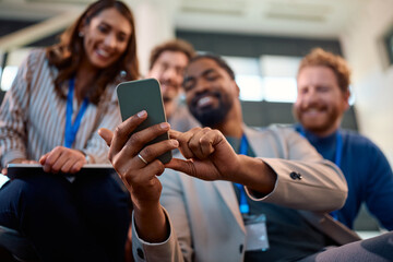 Close up of black entrepreneur talking selfie with his coworkers during business conference.