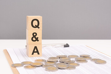 wooden cubes on a brown background with the text Q and A - an abbreviation for Question and Answer....