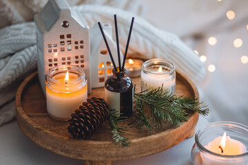 Natural Christmas essential oil, home aroma diffuser. Burning candles, branches of fir tree....