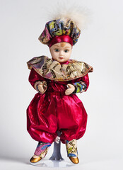 Sweet Porcelain Italian doll depicting the young hero of the Commedia Del Arte in a red suit with golden frills and a hat. - 740303086