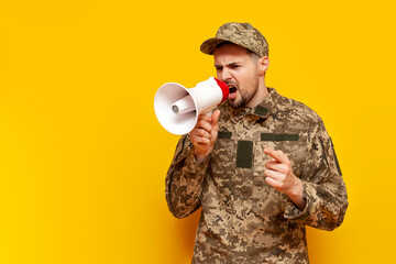 Ukrainian army soldier in pixel military camouflage uniform announces information into megaphone...
