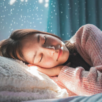 Eine junge Frau tr&auml;umt im Schlaf, w&auml;hrend sie auf einem Bett im flauschigen Pulli liegt