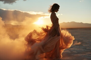 Fototapeta na wymiar A woman in a flowing orange gown poses amidst a dramatic, ethereal mist