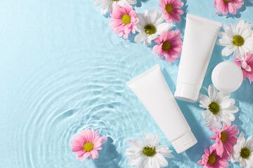 Natural beauty essentials: the purity of organic skincare. Top view of cosmetic tubes, flowers on...