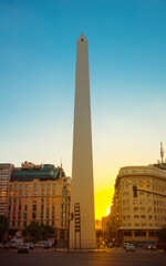 Obelisk of Buenos Aires, Argentina at Sunset. Golden hues paint the sky behind Buenos Aires' iconic Obelisk, creating a breathtaking image.  - obrazy, fototapety, plakaty