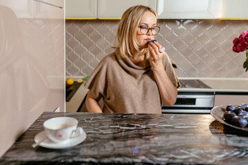 Housewife mature on middle age at kitchen interior.