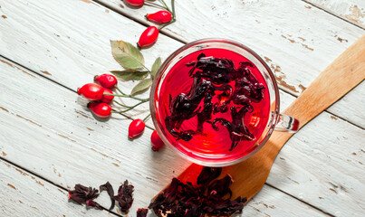 Therapeutic rosehip tea, red tea in a transparent cup, rosehip berry with herbal tinctures for...