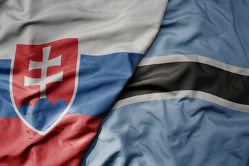 big waving national colorful flag of botswana and national flag of slovakia .
