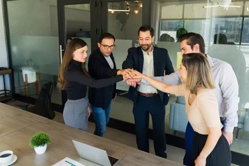  Group of businesspeople coming together as a team and putting their hands together © AntonioDiaz