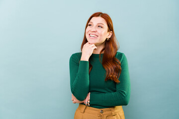 Excited beautiful redhead woman thinking and smiling