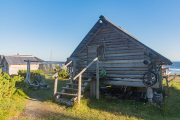 an ancient Pomeranian hut on the seashore against the background of fishing nets and blue sky