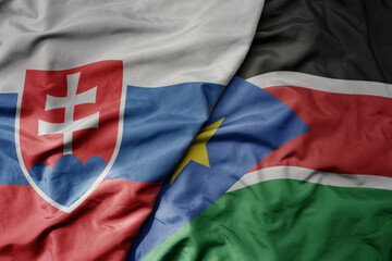 big waving national colorful flag of south sudan and national flag of slovakia .