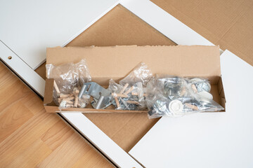 A pile of packed parts of a new furniture, various assembly furniture fittings.