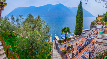 Panorama of lakeside Gandria with olive garden and Friedhof cemetery on the slope, Switzerland