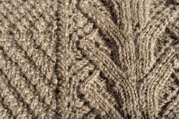 Hand-knitted ecru color pullover, made of Angora wool. Close-up detail. Knitted on spokes. Topic: DIY, handmade, simplicity and convenience of knitted things. Background of ecru color
