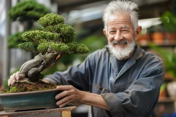 Fotobehang Senior man happily caring for bonsai tree in pot. © Joaquin Corbalan