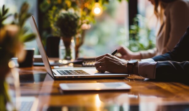 Colleagues working on laptops in modern cafe.