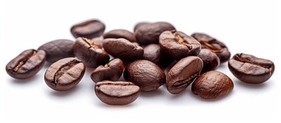 A pile of coffee beans, a singleorigin ingredient from the coffee plant, is displayed on a white background. These natural foods are essential for brewing delicious cups of coffee