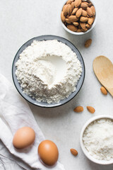 overhead view of mise en place for almond biscotti dough, ingredients for making almond cantucci cookie on a marble countertop