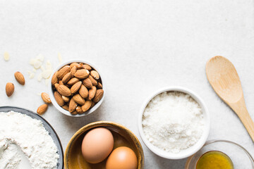 overhead view of mise en place for almond biscotti dough, ingredients for making almond cantucci cookie on a marble countertop