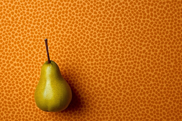 A single green pear against an orange textured background.