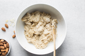 overhead view of almond biscotti dough in a white bowl, almond cantucci cookie dough in ceramic mixing bowl, flatlay of biscotti cookie dough or twice baked cookies