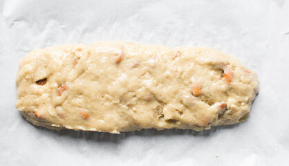 overhead view of almond biscotti dough on parchment paper, almond cantucci cookie dough on parchment lined baking tray, flatlay of biscotti cookie dough or twice baked cookies