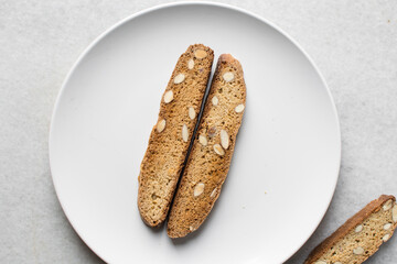 almond biscotti on a white plate, almond cantucci cookies on a white plate, flatlay of biscotti cookies or twice baked cookies