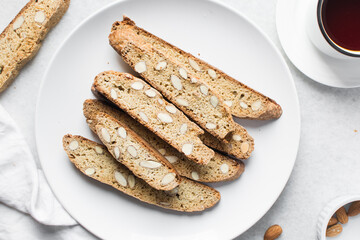 overhead view of almond biscotti on a white plate, almond cantucci cookies on a white plate, flatlay of biscotti cookies or twice baked cookies
