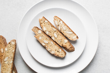 almond biscotti on a white plate, almond cantucci cookies on a white plate, flatlay of biscotti cookies or twice baked cookies
