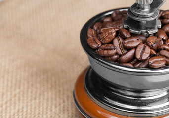 Coffee grinder with freshly roasted coffee beans close-up