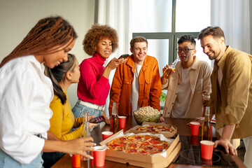 multiracial group of young people at house party ordered pizza and beer and photographed the food on the phone