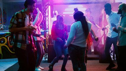 Female dancer partying at nightclub, showing funky dance moves on electronic music at party. Young...