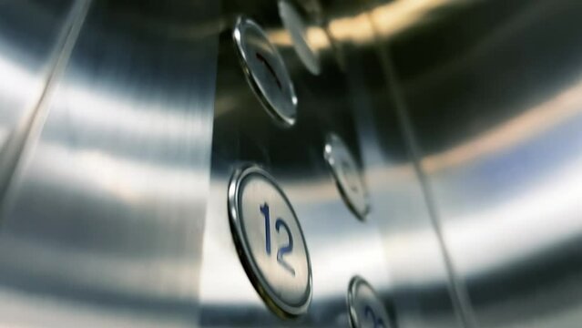 Close-up of the floor buttons of a modern elevator in a hotel or office center. The camera moves up from the bottom, showcasing their design, functionality, and aesthetics. 