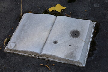 old marble carved book on a grave