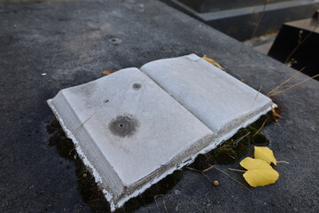 old marble carved book on a grave