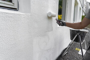 Man Begins Applying Cement Based Putty: Wall Renovation in Progress.