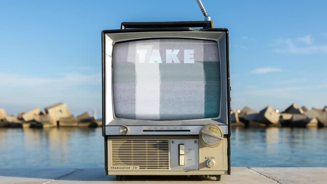 retro television on a beach next to the sea