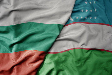 big waving national colorful flag of uzbekistan and national flag of bulgaria .