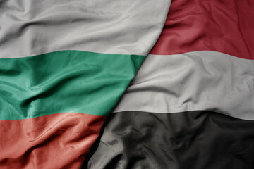 big waving national colorful flag of yemen and national flag of bulgaria .